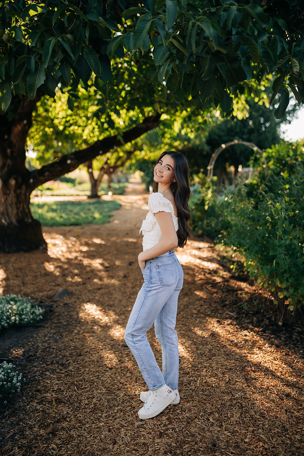 a girl standing in a park posing for her photos
